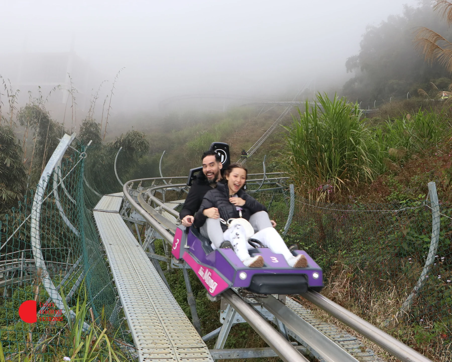 Alastair and Candice riding the purple Bản Mòng alpine coaster in the mist