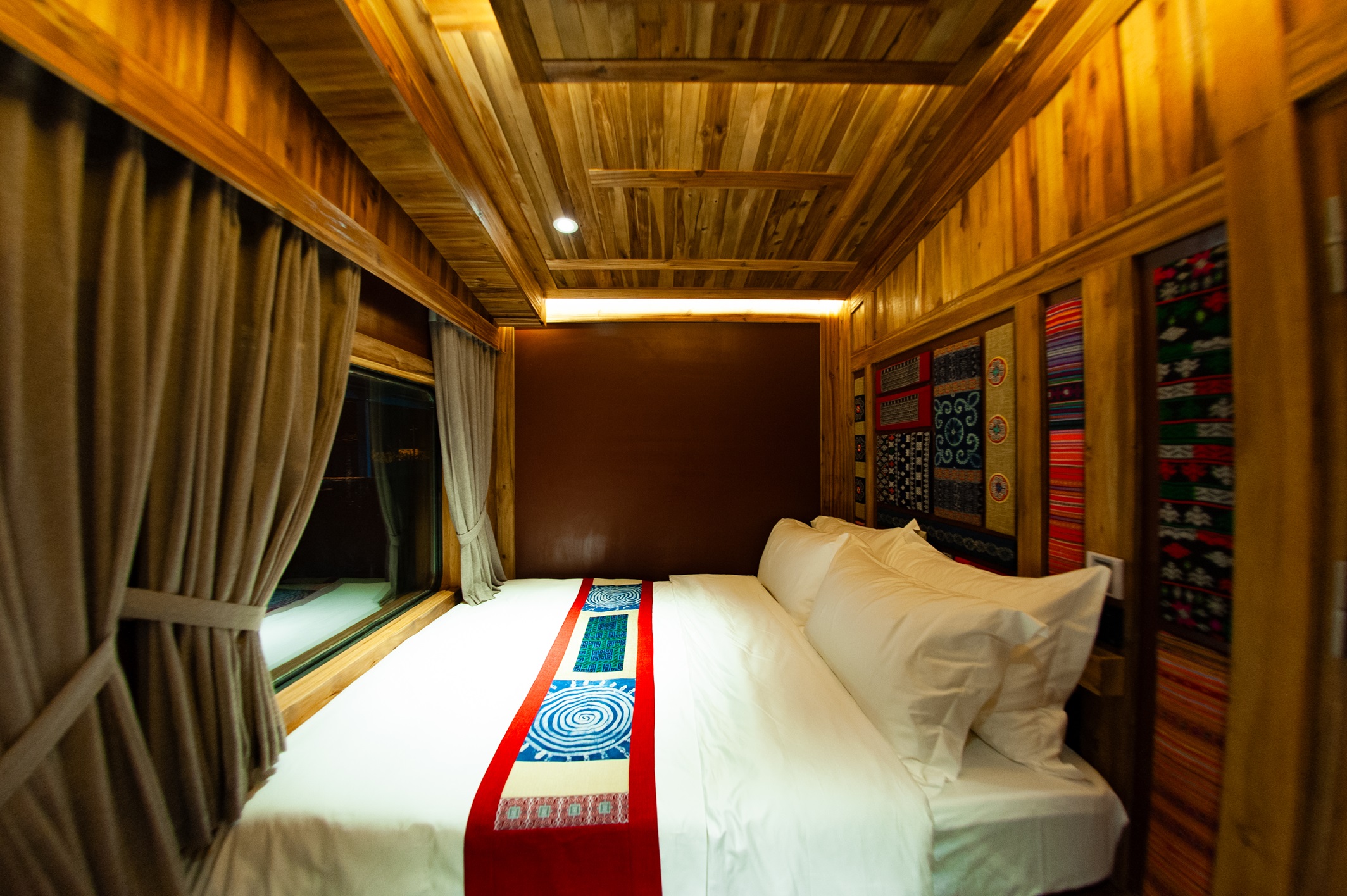 A proper double bed inside Chapa Express’s wood-panelled Grand Suite Queen cabin